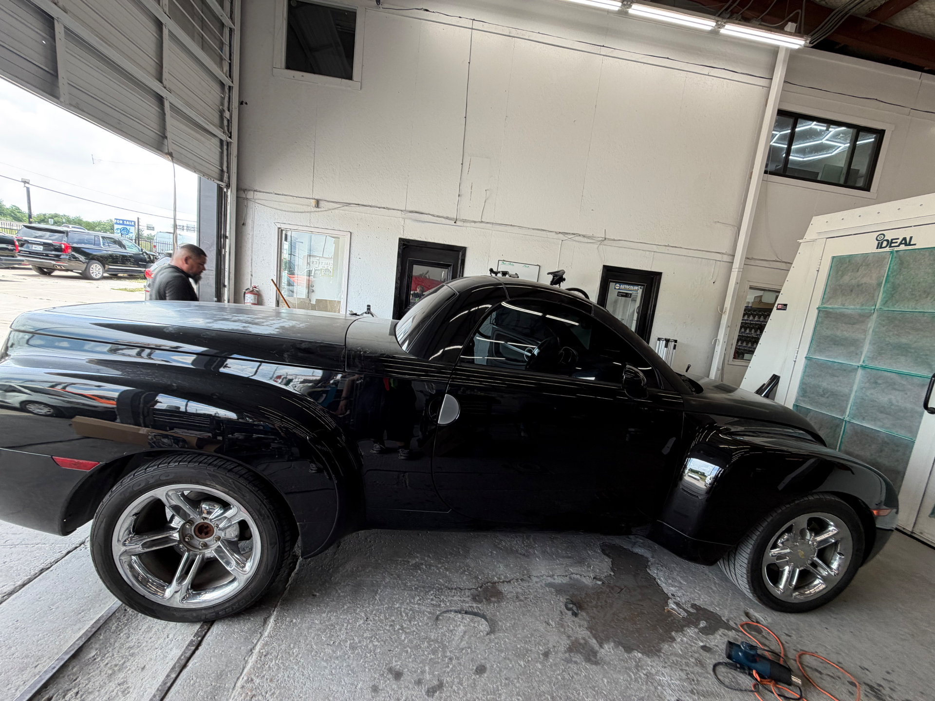 A glossy black custom coupe positioned inside the Unique Visions studio.